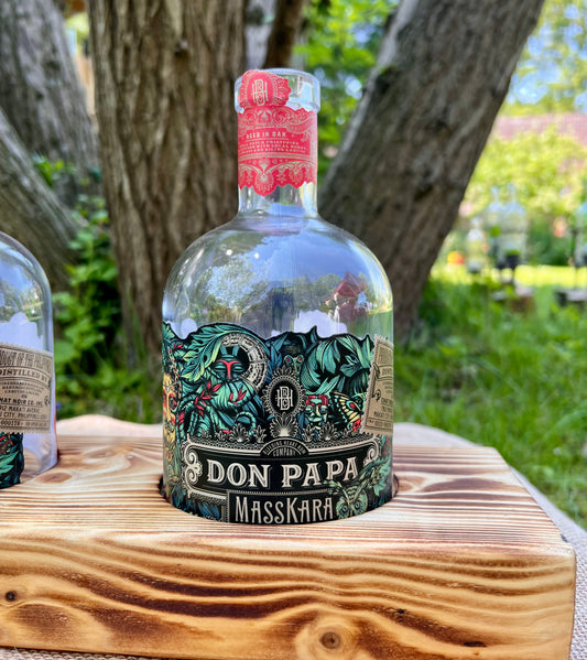 Tischleuchter mit Don Papa Flaschen auf geflammtem Kantholz dreiflammig