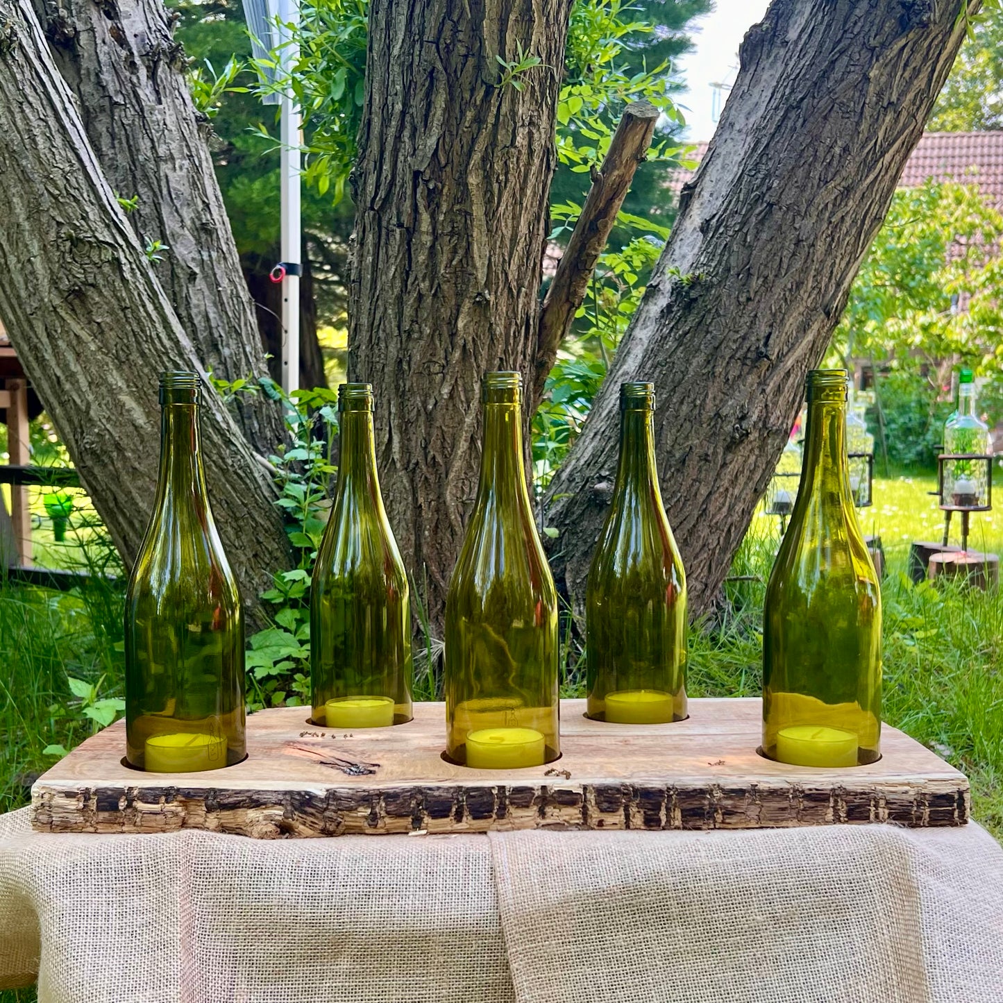 Tischleuchter aus Weinflaschen auf Holzbrett fünfflammig